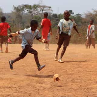 Fußball spielende Kinder, Dorf in Kamerun, kaputter Ball